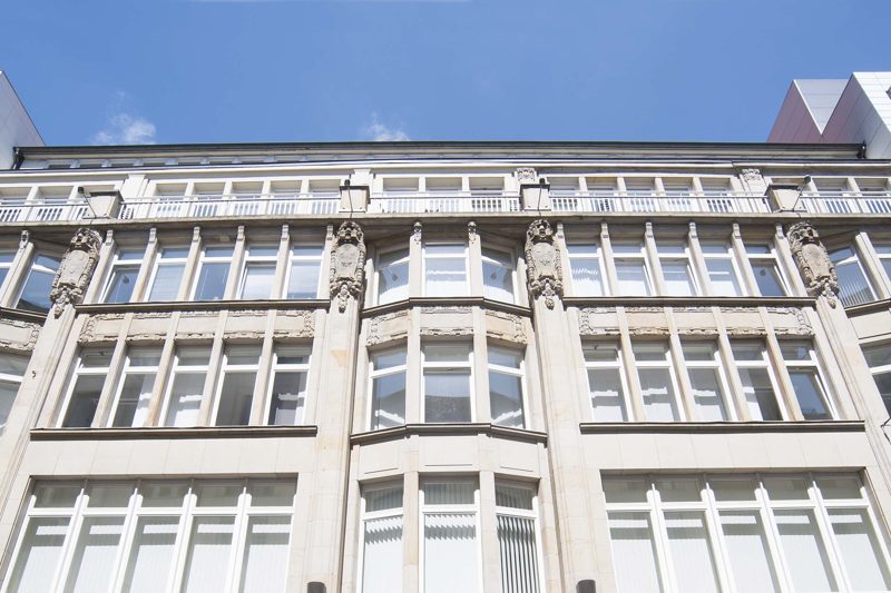 Obere Geschosse der Fassade vor blauem Himmel