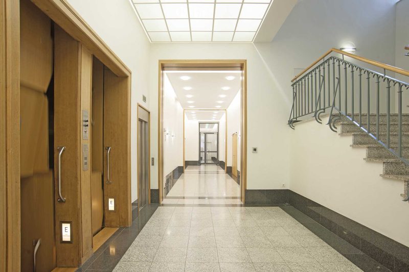 Flur mit Holztüren und Treppengeländer im Foyer