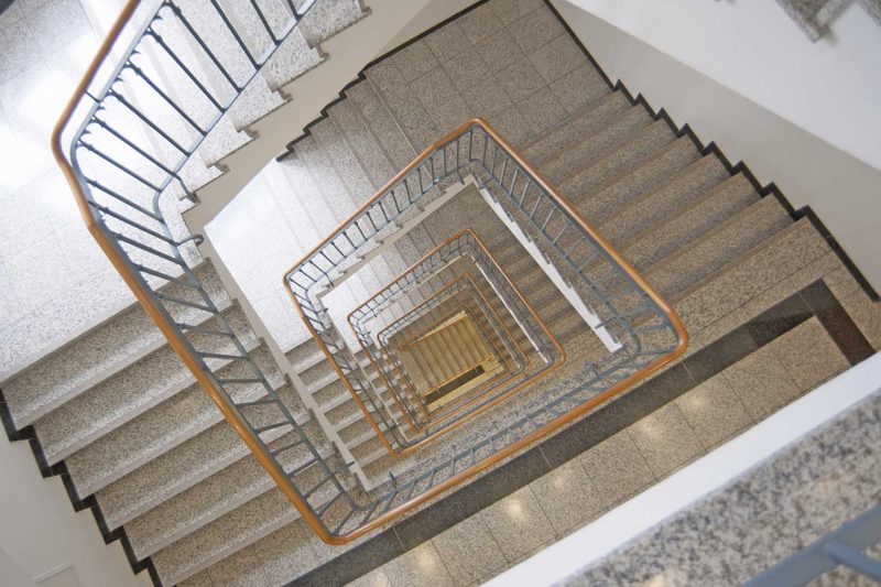 Blick von oben in das Treppenhaus mit Holzhandlauf