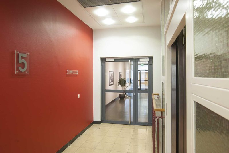 Flur mit roter Wand und Geschossziffer 5